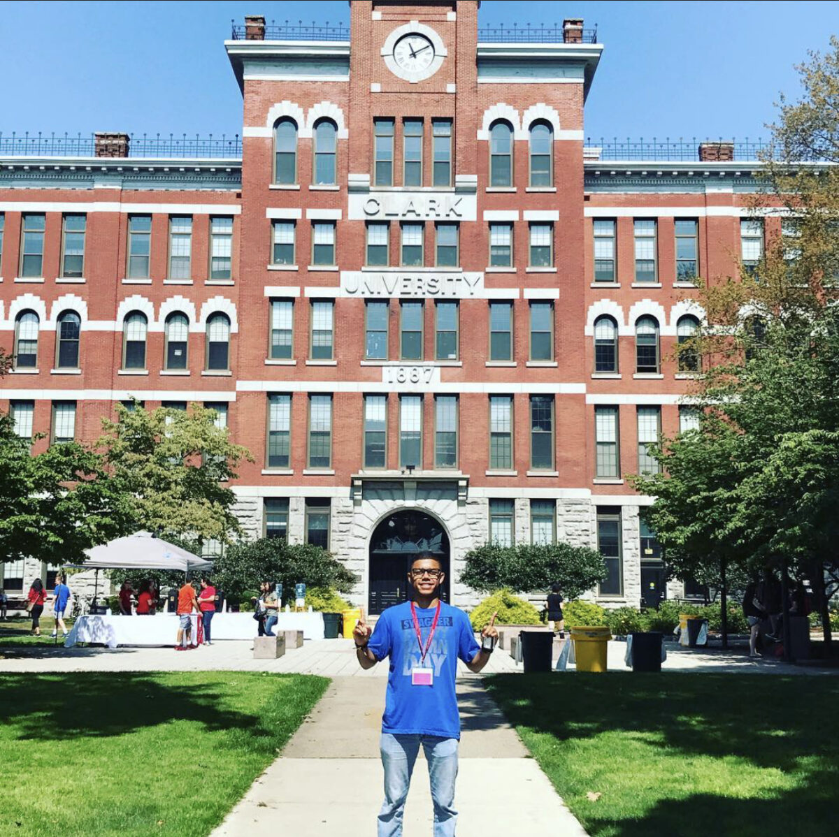 Student poses in front of brick building