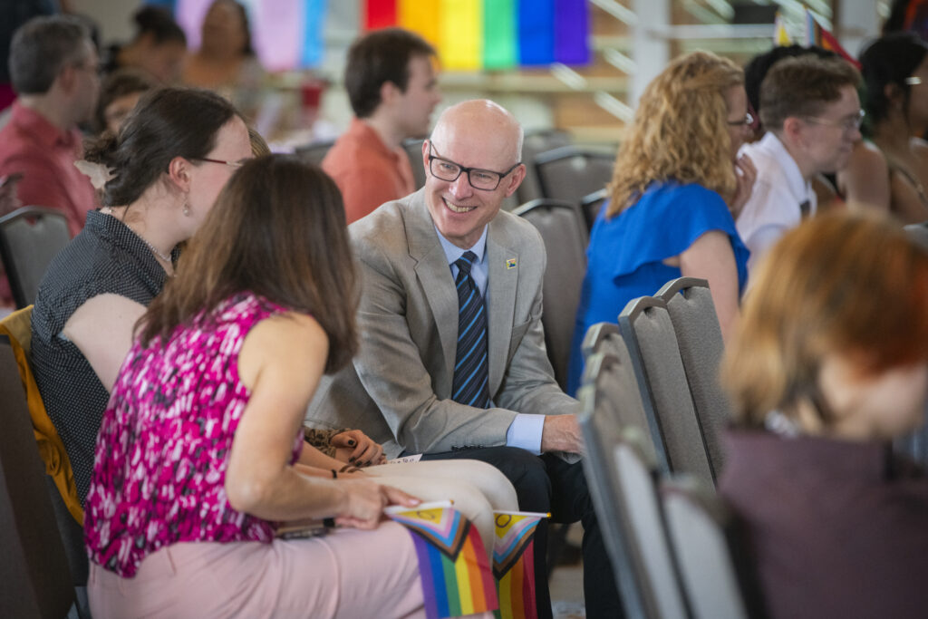 people pose for photos at lavender graduation ceremony
