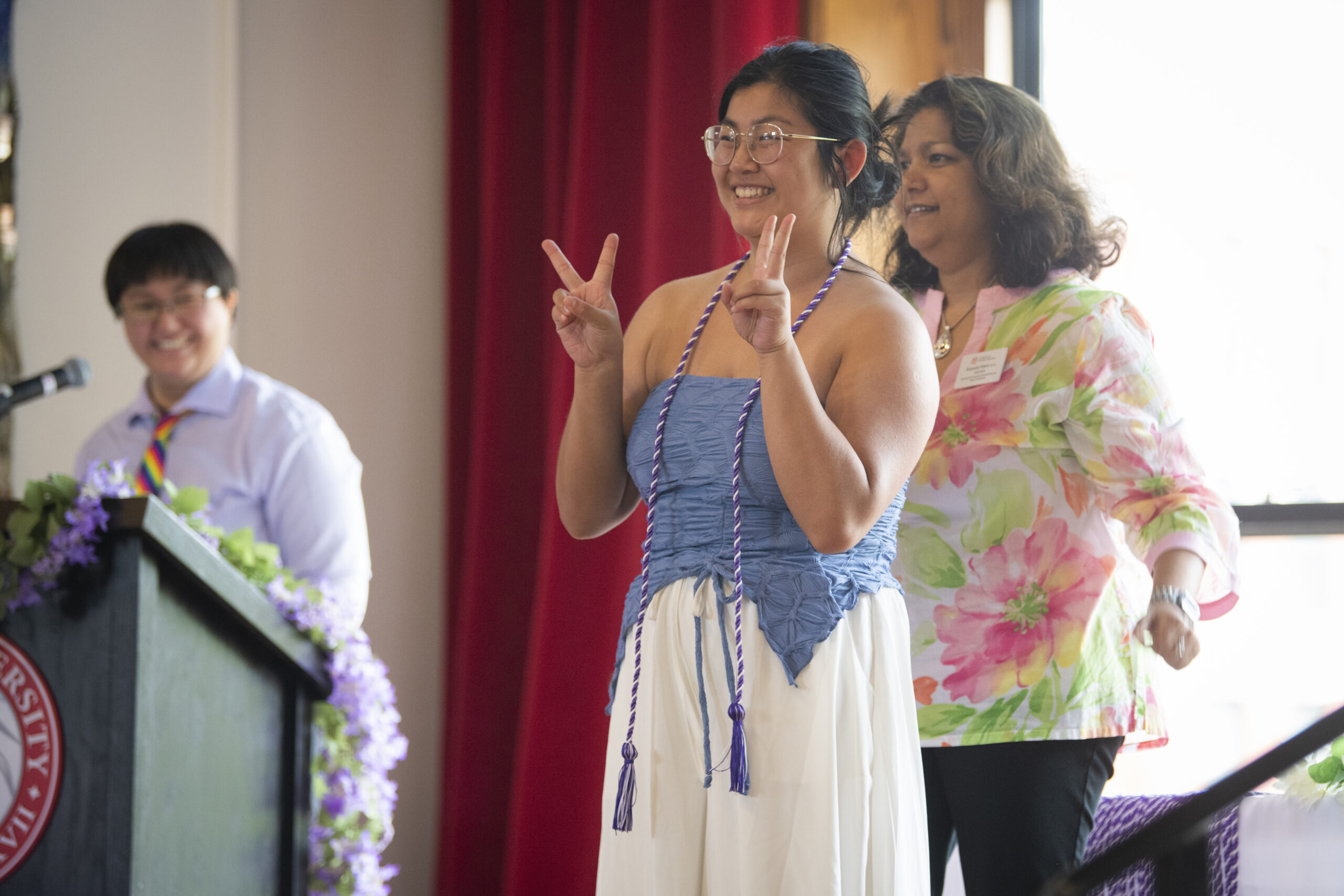 people pose for photos at lavender graduation ceremony