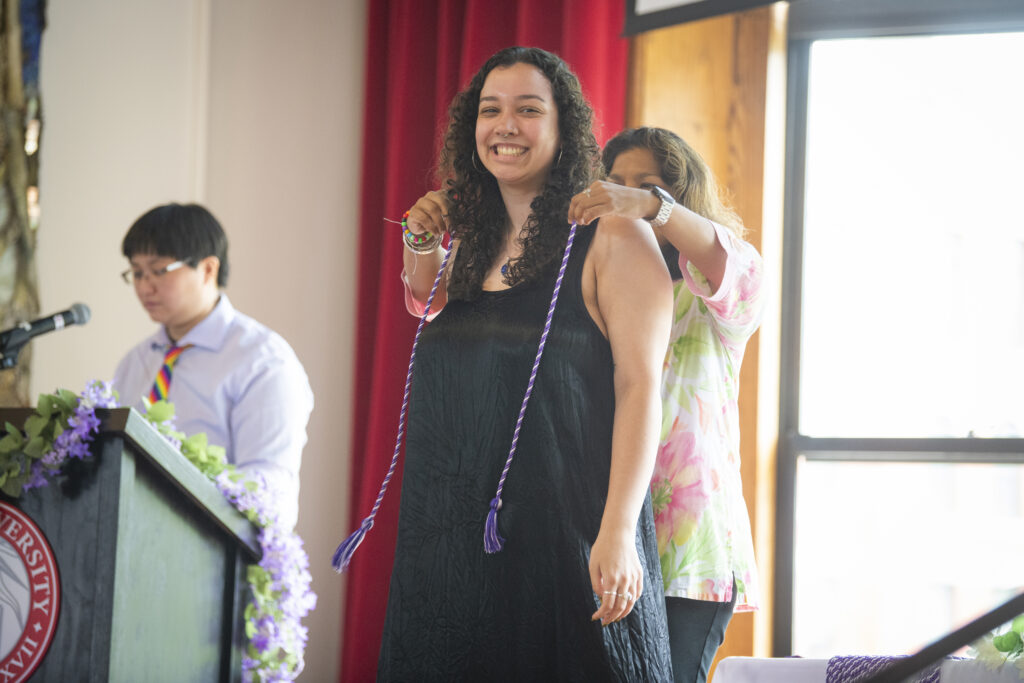 people pose for photos at lavender graduation ceremony