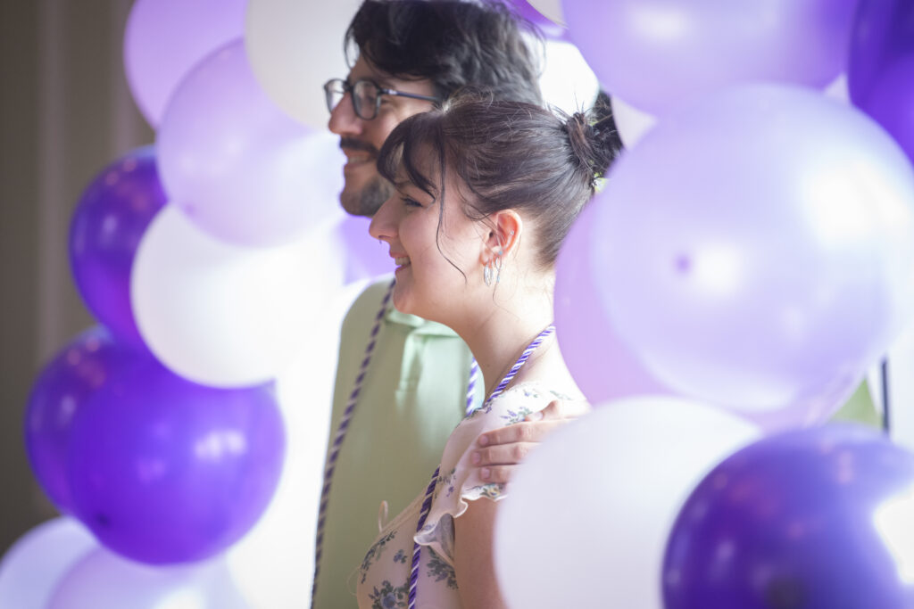 people pose for photos at lavender graduation ceremony