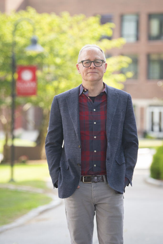 man wearing blazer stands on campus