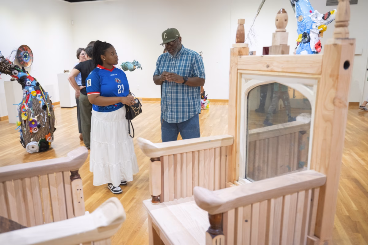 wooden thrones in art gallery with people standing nearby