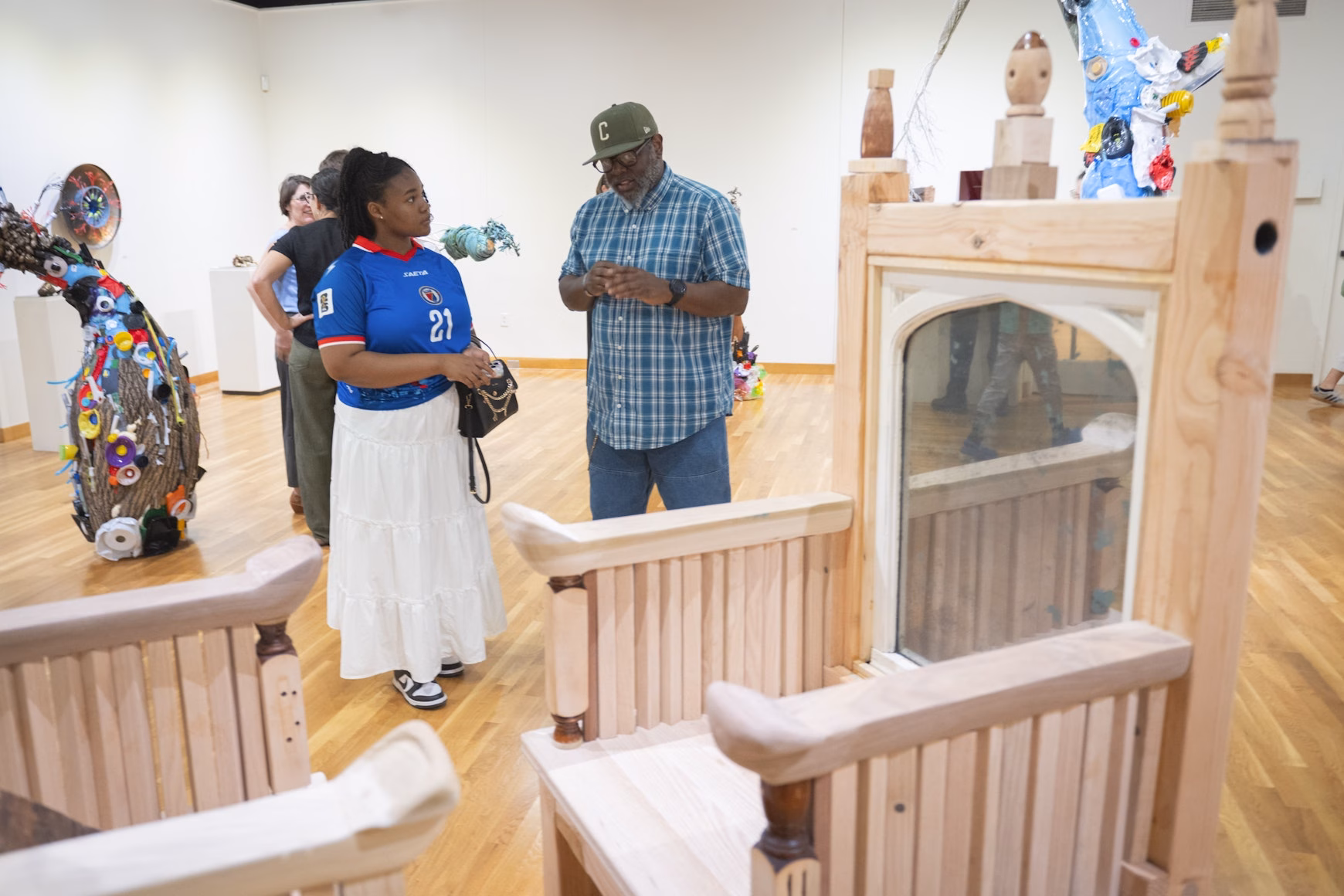 wooden thrones in art gallery with people standing nearby