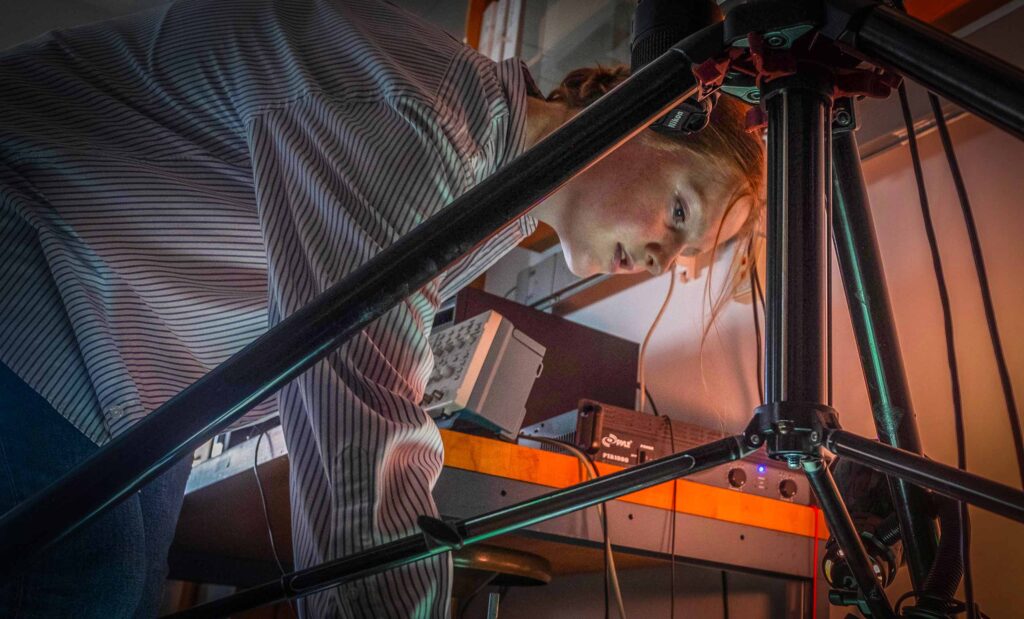 Lily Carey '25 works in the Kudrolli Physics Lab on a robotic experiment.