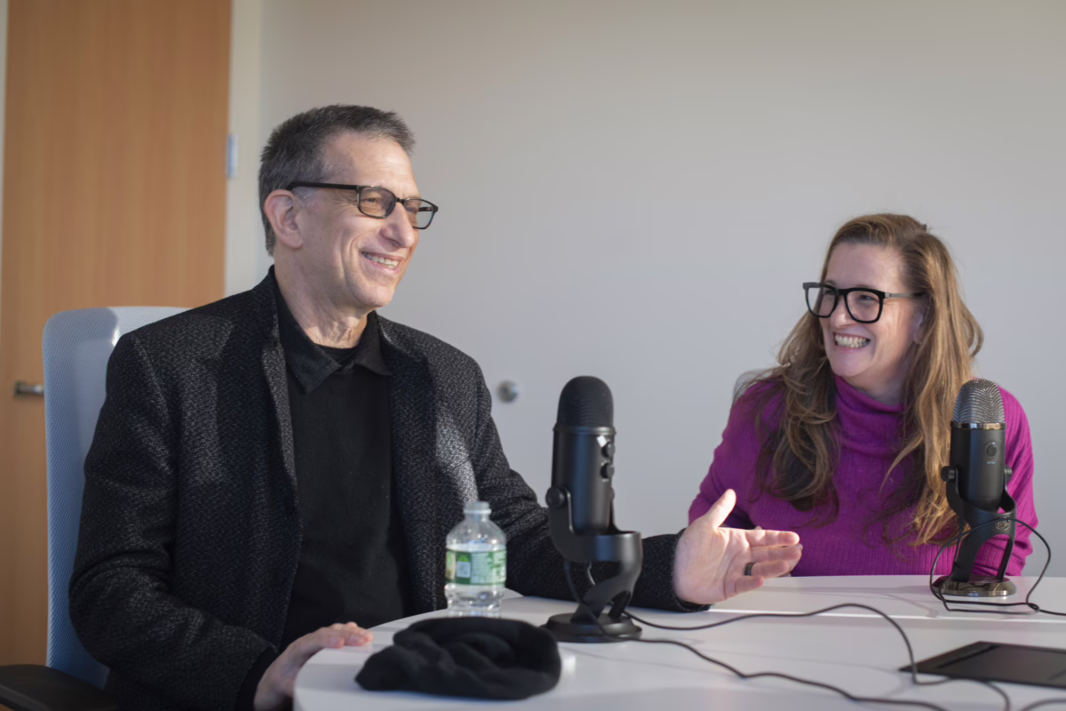 two people sitting at podcast mics