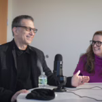 two people sitting at podcast mics