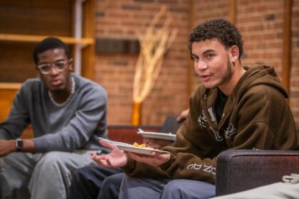 Students eat and converse at an event held by the Men of Color Alliance at Clark University