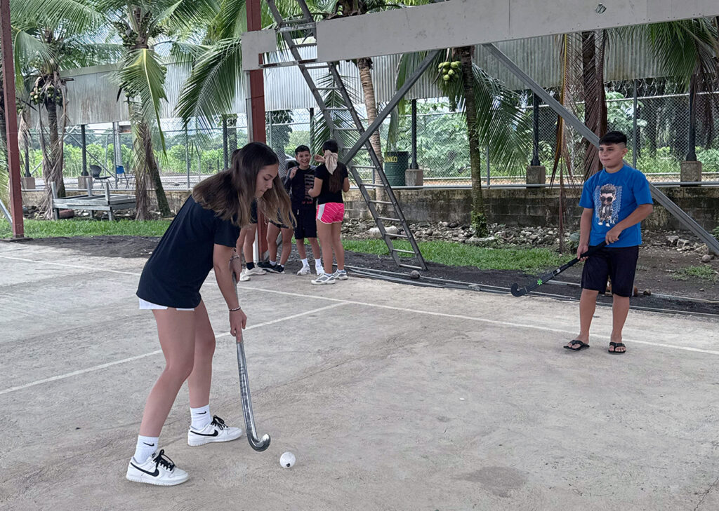 In Costa Rica, Morgan Brown ’26 teaches a Cerros Elementary School student about field hockey.