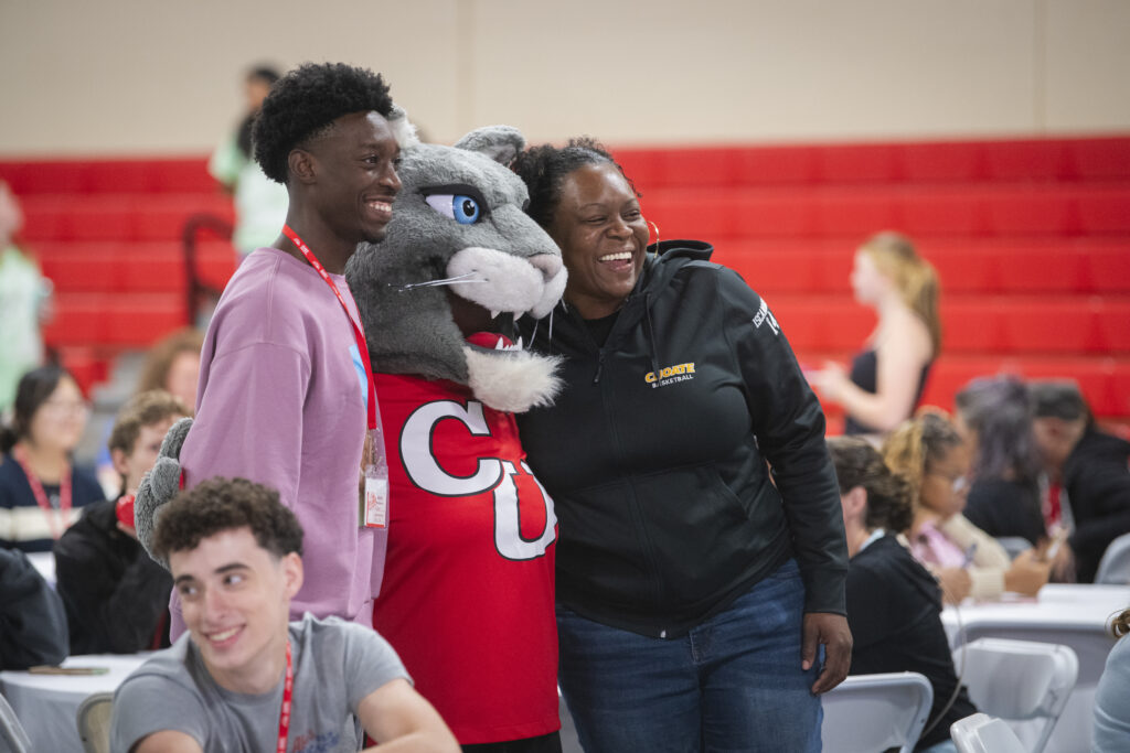 family poses with mascot