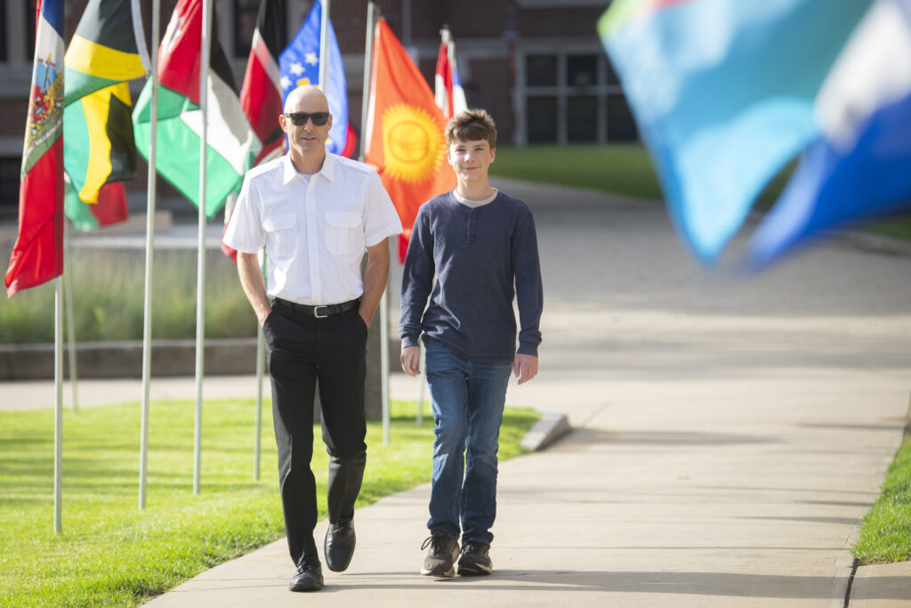 two people walk on campus sidewalk