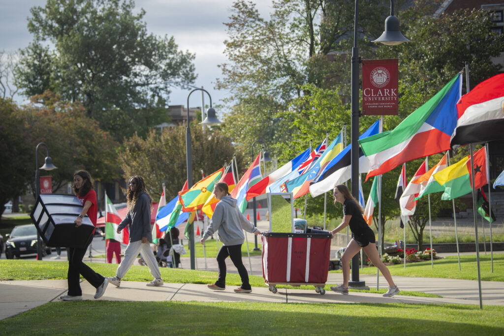 two students push bin on sidewalk