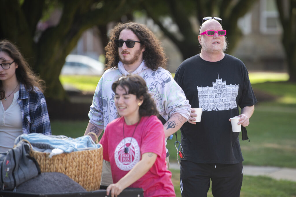 four people stand on campus