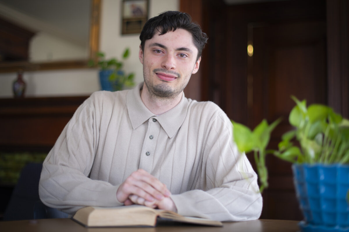 student poses for headshot with book