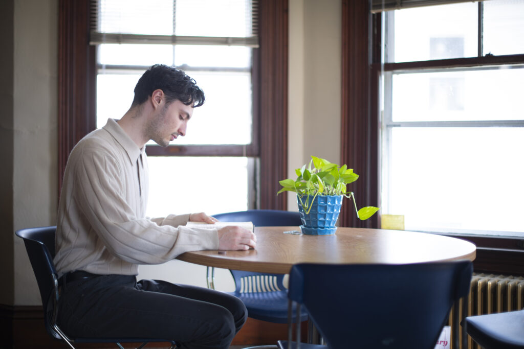 student reads book at table
