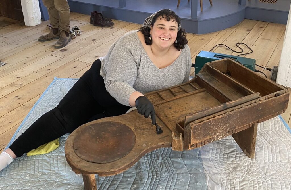 Hannah Friend ’23, M.A. ’24, with a historic bench at Old Sturbridge Village.
