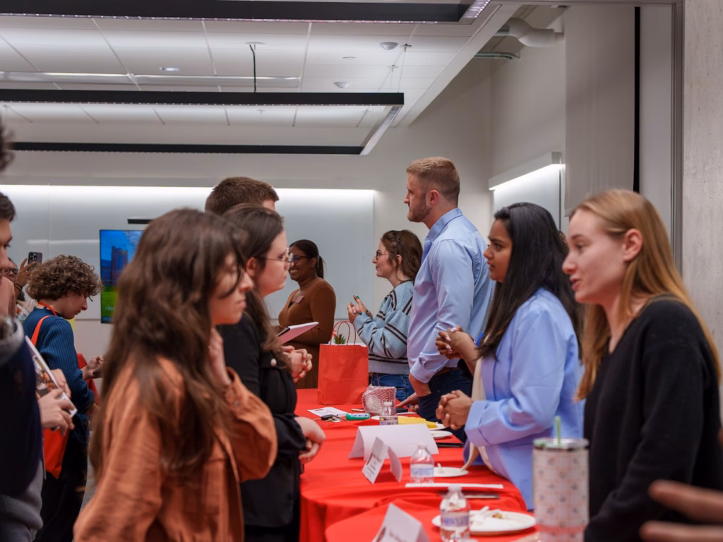 students talk to alumni across table at career event