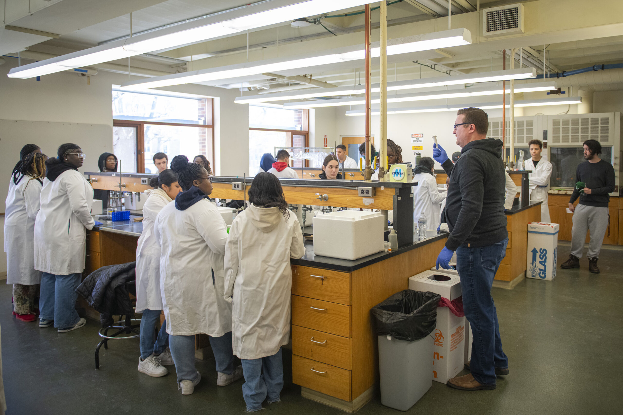 Professor Don Spratt talks to North High School students before they conduct experiments in the lab.
