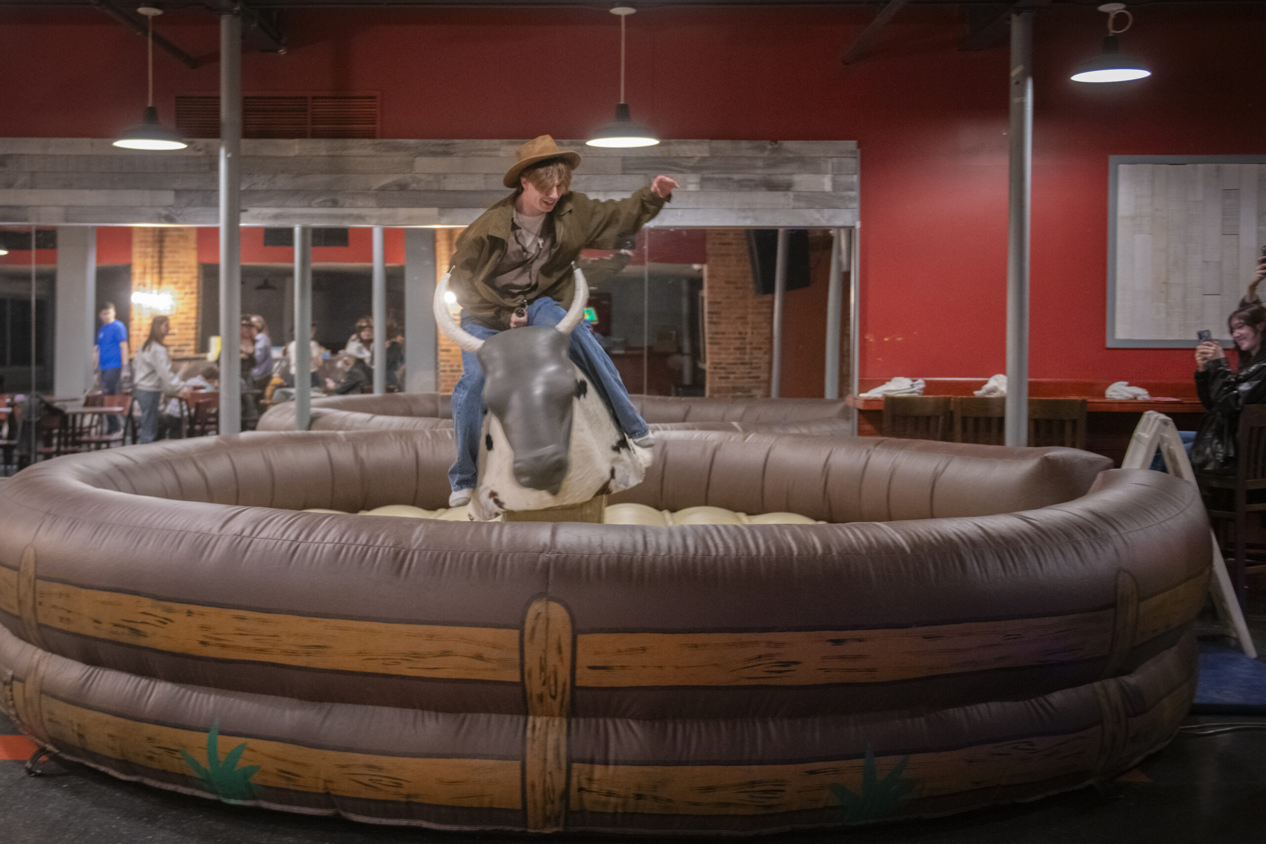 student rides inflatable bull