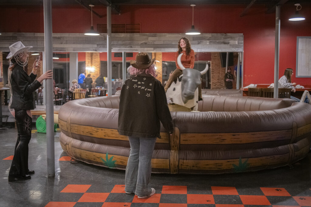 student rides inflatable bull