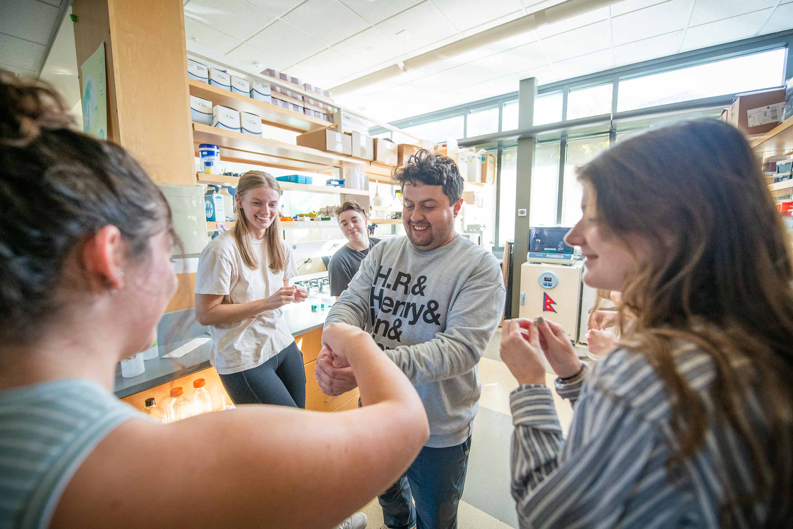 Javier Tadima interacting with biology student in the lab