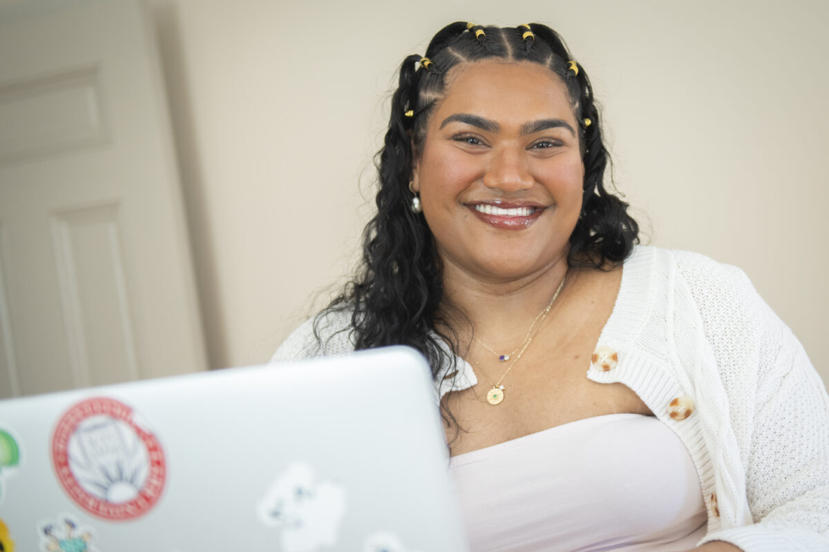 student poses for photo with laptop