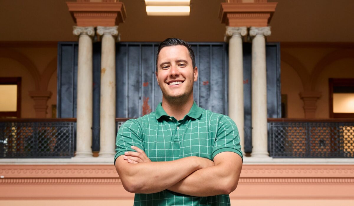 headshot of man wearing green shirt