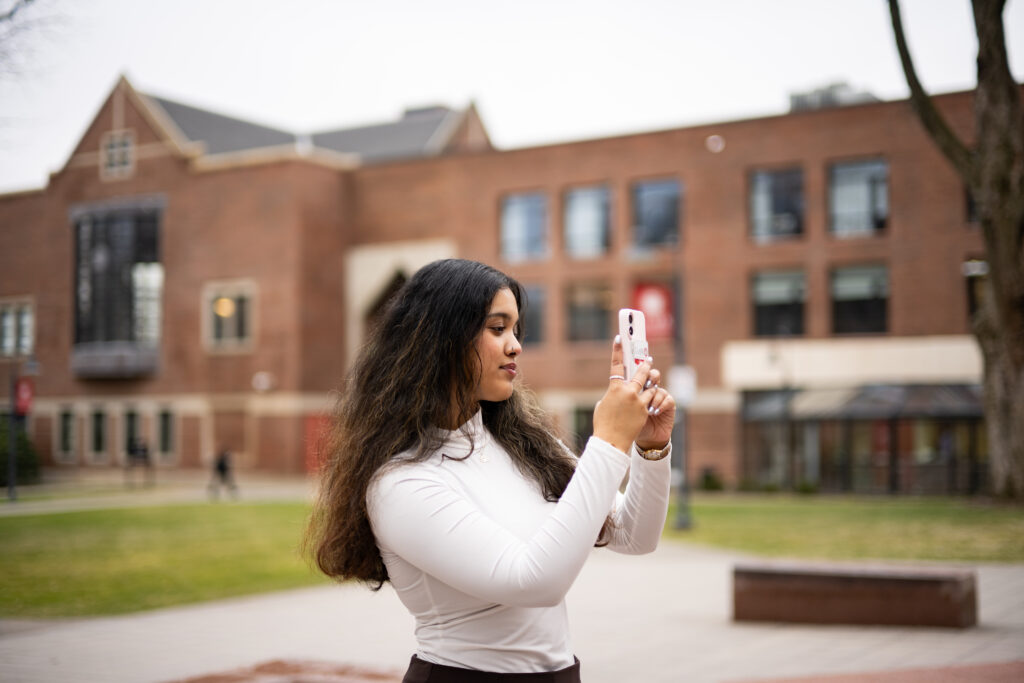 student records video on phone on campus green