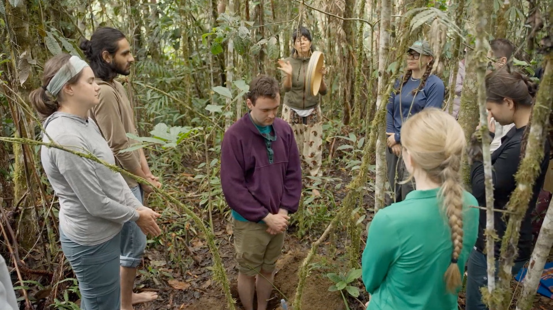 Zach meditates in the middle of the forest, surrounded by his fellow classmates