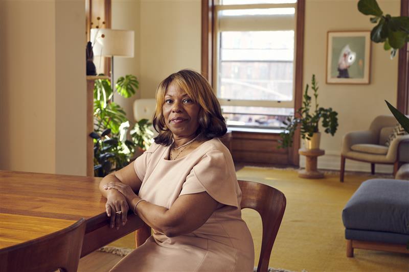woman sits at table in house