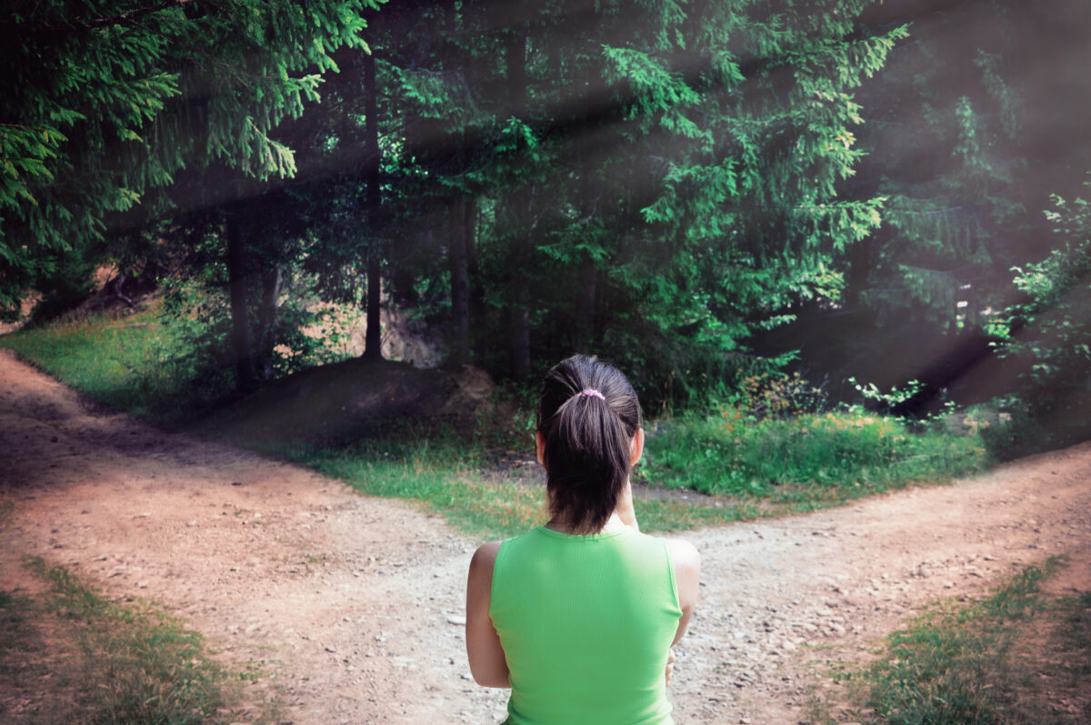Woman standing at fork in the road