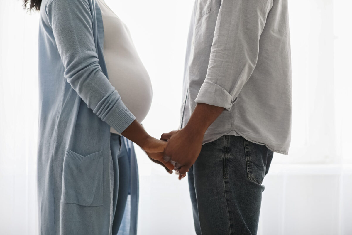pregnant couple holding hands