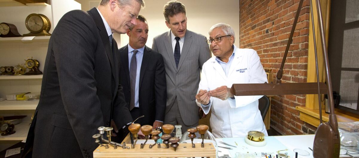 Jay Ash '83 (center) and Gov. Charlie Baker (left) visit a Massachusetts clockmaker