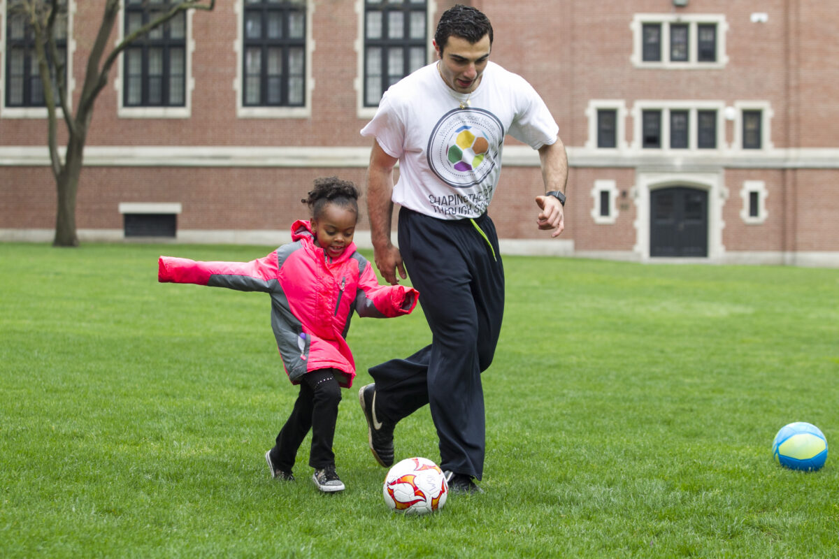 mohamed playing soccer with a child