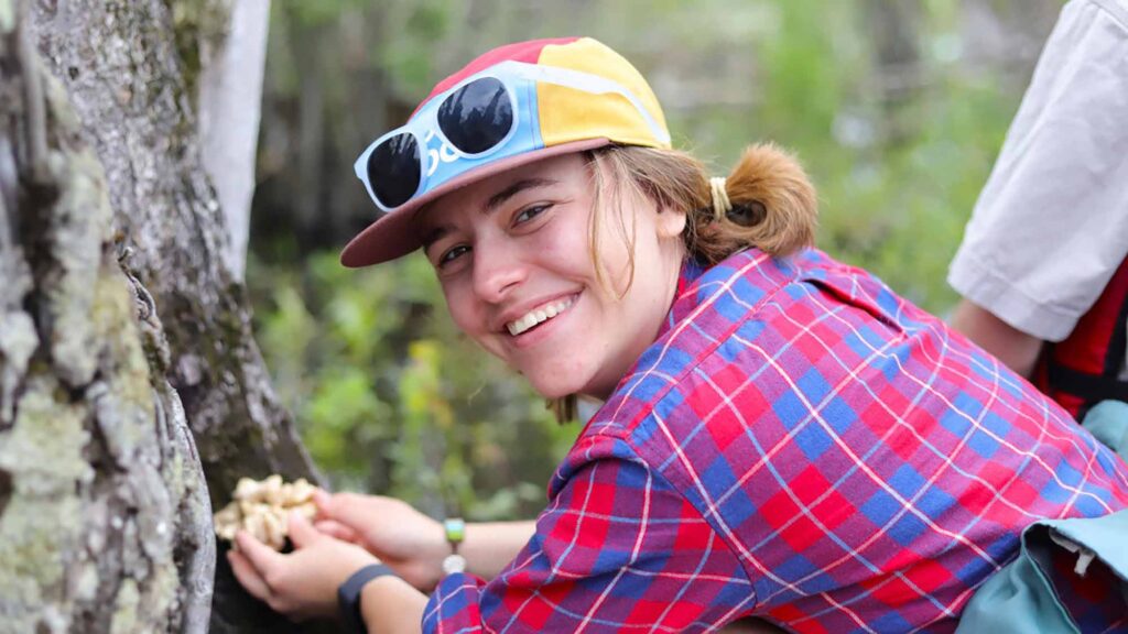 Devon Rose Leaver holding mushroom on a tree