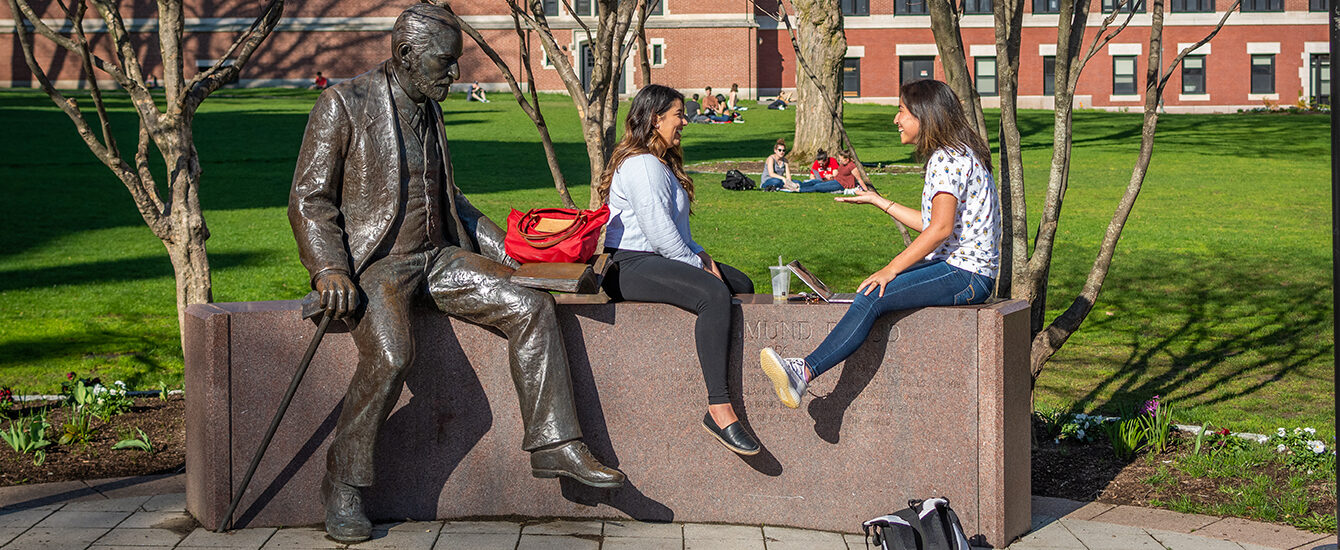 girls sitting on the wall with freud statue