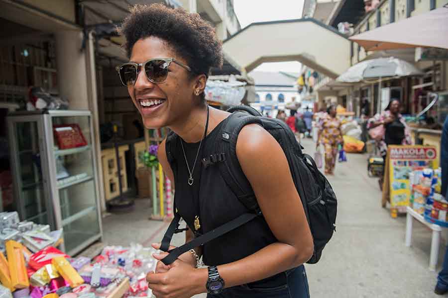 A Peace Corps volunteer smiling in a busy marketplace