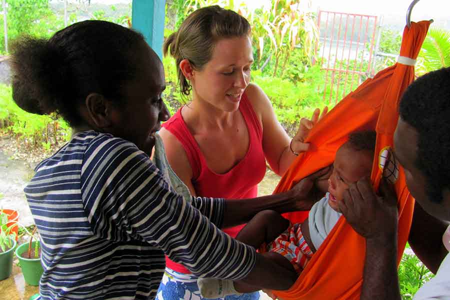 A Peace Corps volunteers works with a family in their host community.