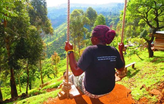Student swinging on swing over the Sipi Falls