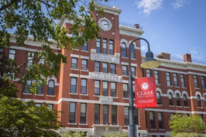 Jonas Clark Hall behind a lamppost and Clark University banner