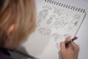 A student works on a series of character drawings during a 2D drawing class.
