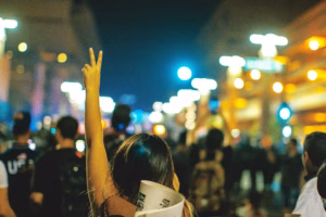 Person at a protest in Phoenix Arizona makes the hand sign for peace