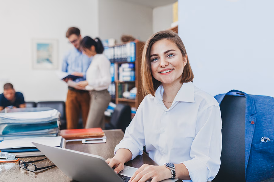 advanced graduate study - Young businesswoman working on her laptop and smiling
