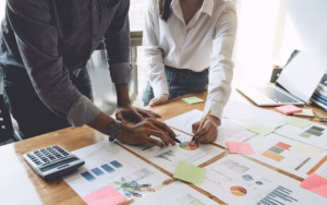 project management - two marketing professionals looking over gant charts