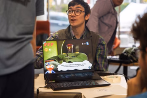 A student presenting a game with a concept involving unsent love letters at ClarkFest a celebration of original research, practice, and creative work.