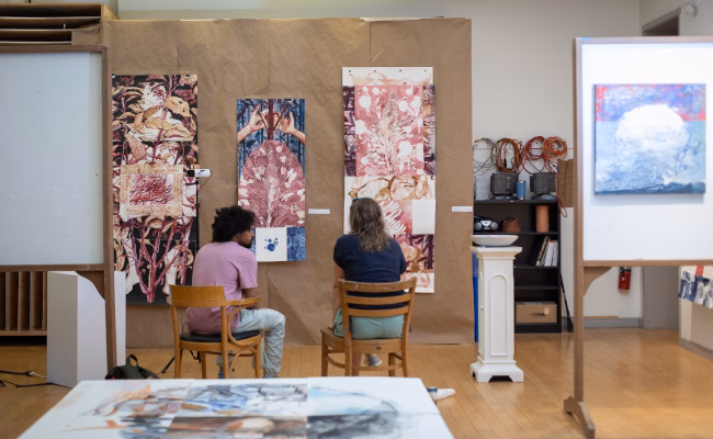 Two students discussing colorful art piece