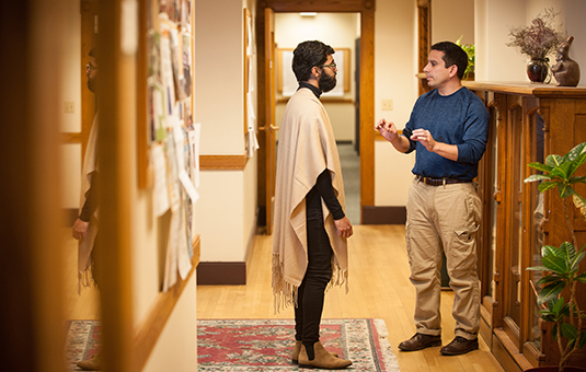 graduate student in hall way with faculty member