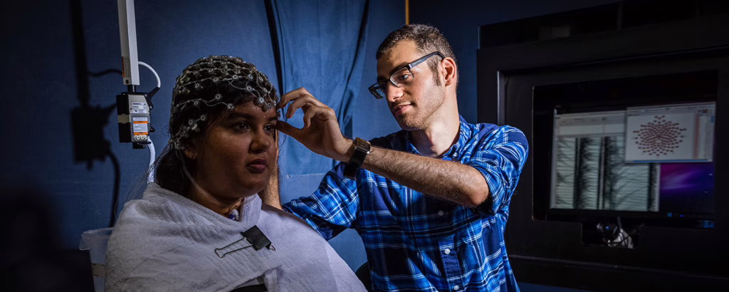 student working with subject putting mind cap on