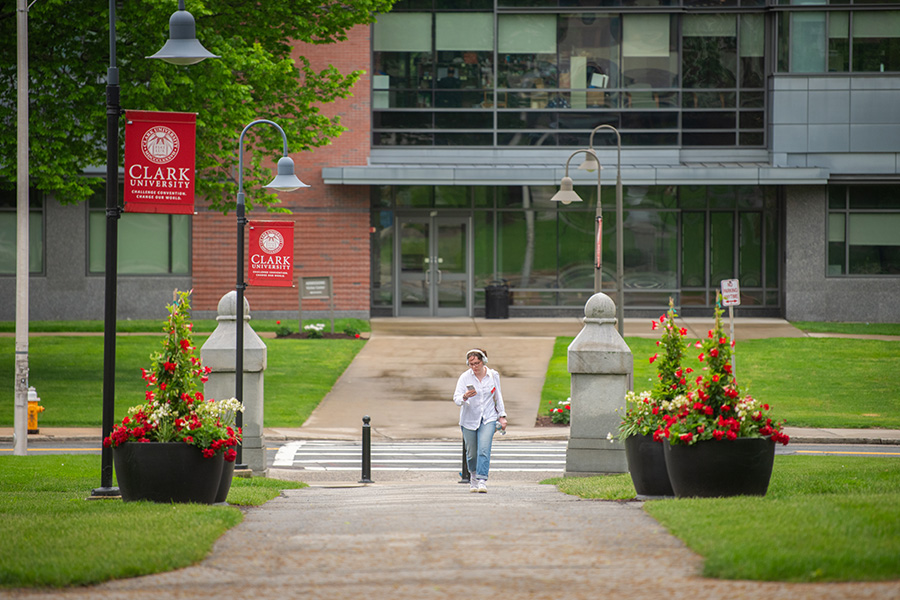 young lady walking across campus