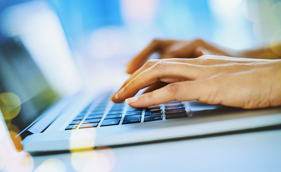 Shot of an unrecognizable businesswoman typing on her laptop at her office desk at work